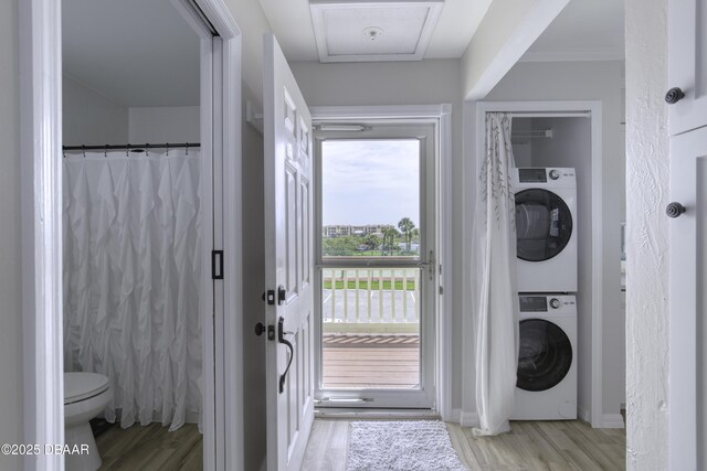1101 Ocean Marina Dr Unit 201, Flagler Beach, FL 32136 - laundry room featuring stacked washer and clothes dryer, wood finished floors, and baseboards