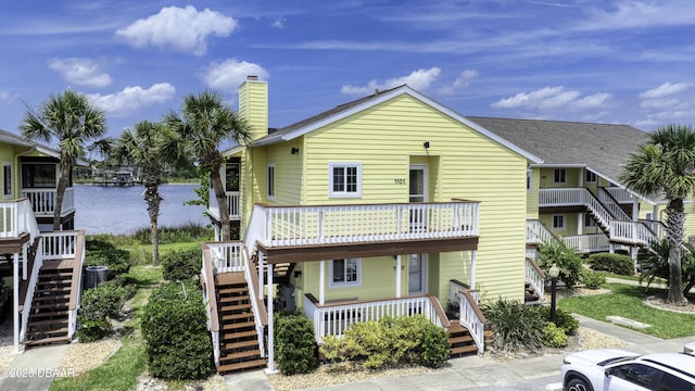 1101 Ocean Marina Dr Unit 201, Flagler Beach, FL 32136 - view of front facade with stairway, a water view, and a chimney