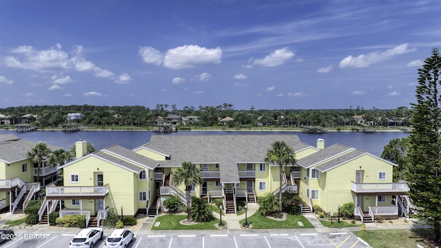 1101 Ocean Marina Dr Unit 201, Flagler Beach, FL 32136 - view of front of house with uncovered parking, a chimney, a water view, and stairs