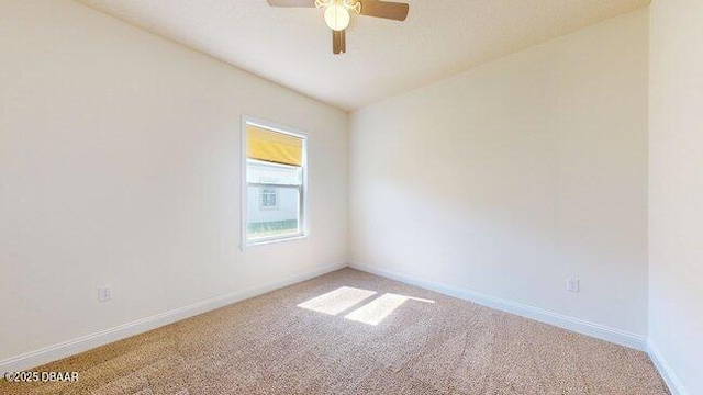 spare room with baseboards, ceiling fan, and light colored carpet