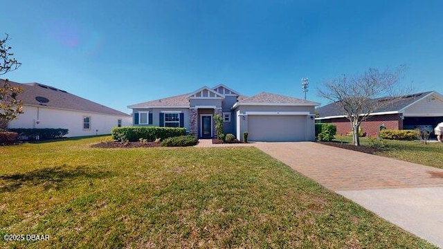 view of front of property featuring an attached garage, decorative driveway, and a front yard