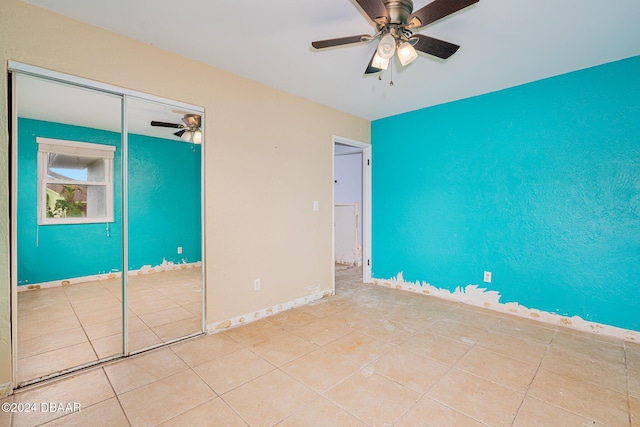 unfurnished bedroom with ceiling fan, light tile patterned flooring, and a closet