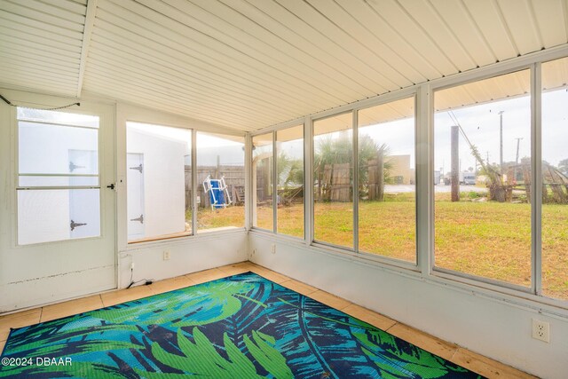 unfurnished sunroom featuring vaulted ceiling