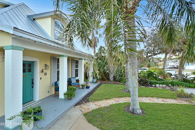 entrance to property with a yard and covered porch