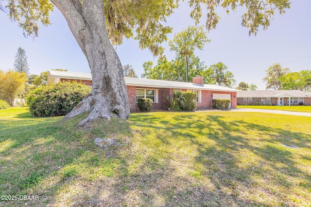 ranch-style home featuring brick siding, a front lawn, and a garage