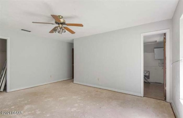 unfurnished bedroom featuring ensuite bathroom, ceiling fan, a closet, and a walk in closet