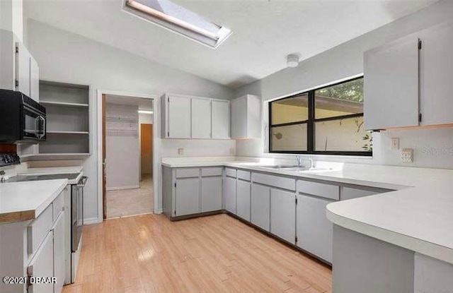 kitchen with gray cabinets, light hardwood / wood-style flooring, lofted ceiling, and white range with electric cooktop