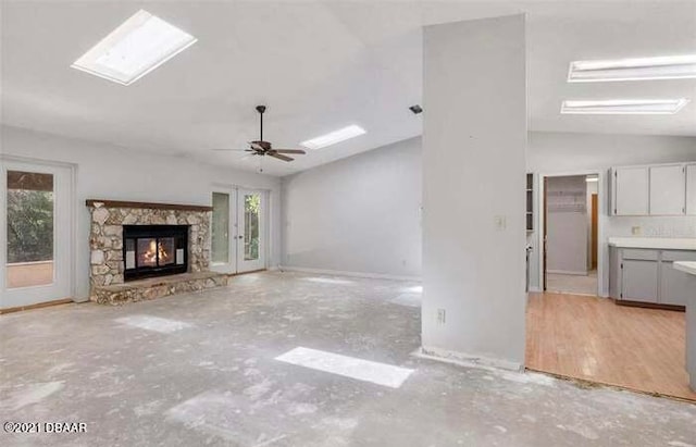 unfurnished living room featuring a fireplace, light hardwood / wood-style floors, ceiling fan, and lofted ceiling