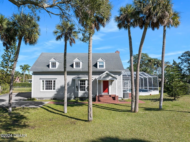 cape cod home with a lanai and a front yard