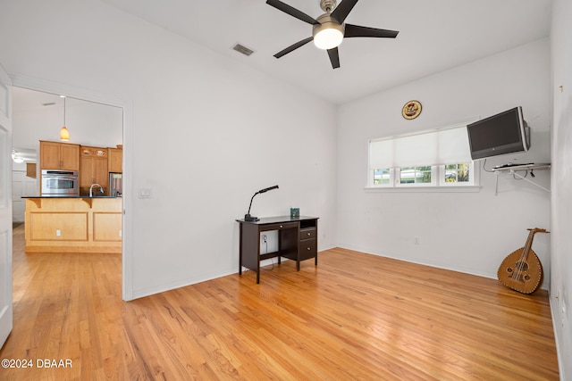 interior space featuring light wood-type flooring, ceiling fan, and sink