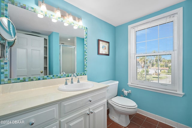 bathroom featuring toilet, vanity, tile patterned floors, and a shower with shower door