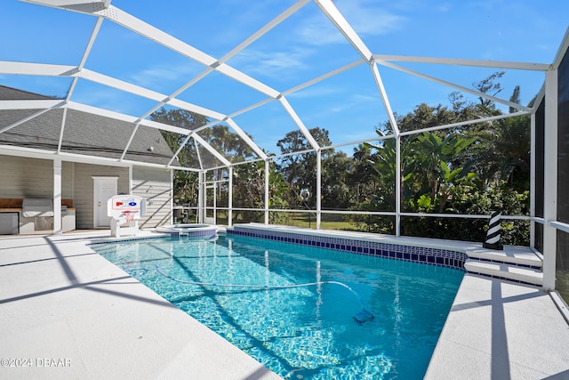 view of pool with glass enclosure and a patio area