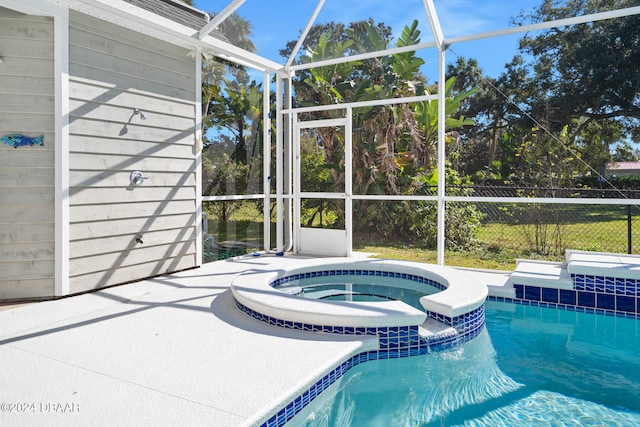 view of pool with a lanai, a patio, and an in ground hot tub