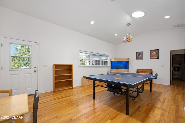 playroom featuring plenty of natural light, washer / dryer, vaulted ceiling, and light hardwood / wood-style flooring