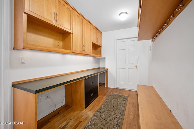 kitchen featuring built in desk and light hardwood / wood-style flooring