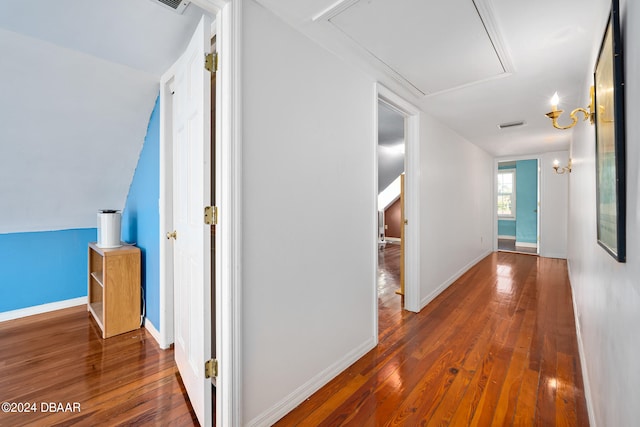 hall with dark wood-type flooring and vaulted ceiling