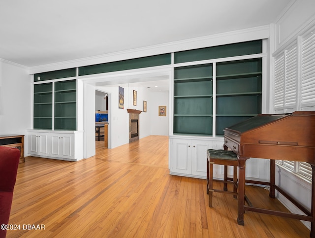 miscellaneous room with built in features, light wood-type flooring, and crown molding