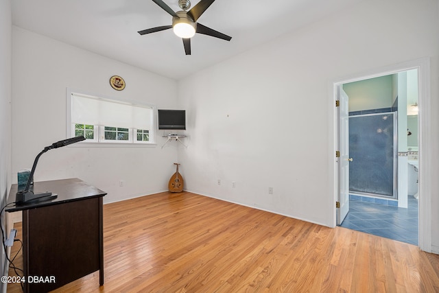 home office with light wood-type flooring and ceiling fan