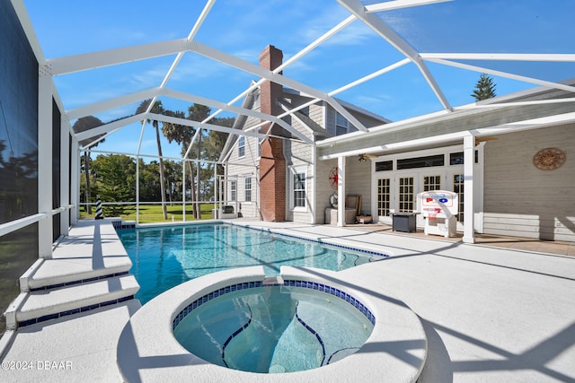 view of pool featuring ceiling fan, glass enclosure, and a patio area