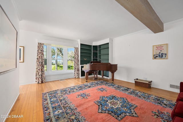 interior space featuring ornamental molding, wood-type flooring, and beam ceiling