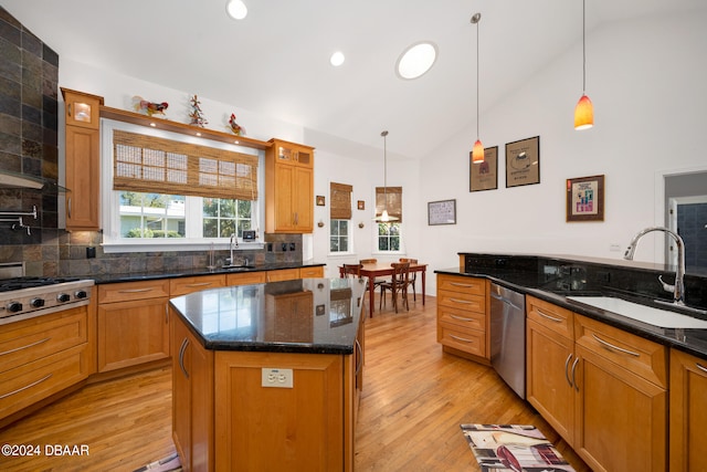 kitchen featuring a kitchen island, pendant lighting, appliances with stainless steel finishes, and light hardwood / wood-style flooring