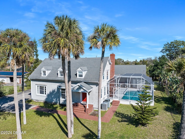 view of front of house featuring a front lawn, a lanai, central AC, and a patio area