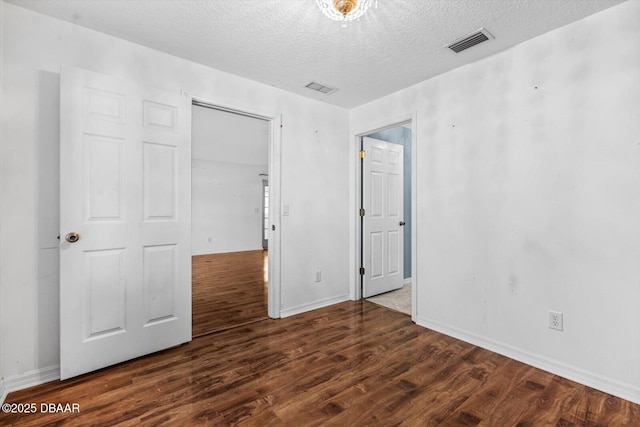 unfurnished bedroom featuring dark hardwood / wood-style flooring and a textured ceiling