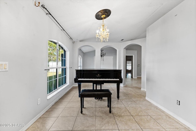 miscellaneous room featuring a chandelier, light tile patterned floors, and vaulted ceiling