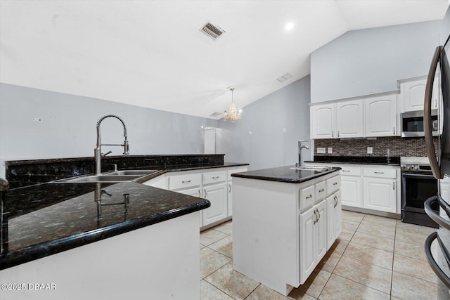 kitchen with white cabinets, sink, an island with sink, and lofted ceiling