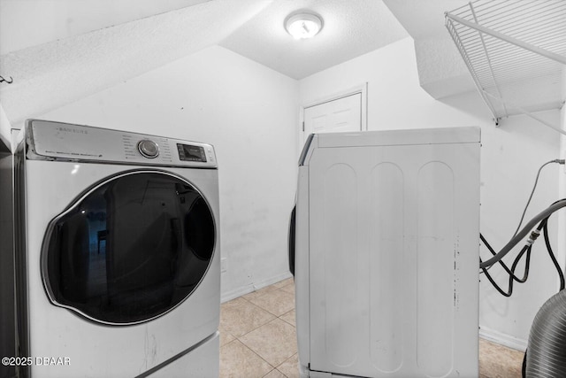 laundry room featuring independent washer and dryer, a textured ceiling, and light tile patterned floors