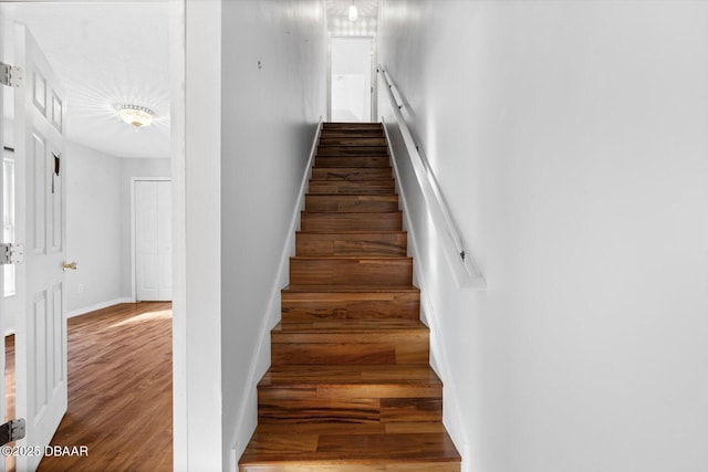 stairs featuring hardwood / wood-style floors