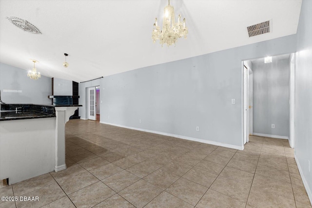 unfurnished living room featuring a notable chandelier, light tile patterned flooring, and lofted ceiling