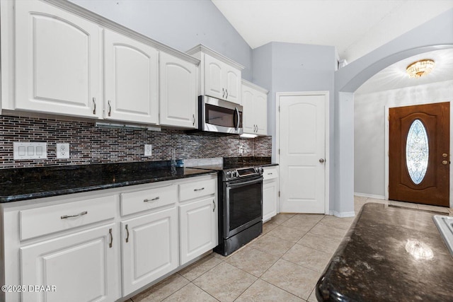 kitchen with backsplash, vaulted ceiling, black electric range, light tile patterned floors, and white cabinetry