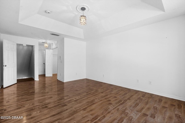 spare room featuring dark hardwood / wood-style flooring and a tray ceiling