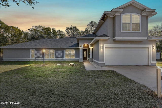 front of property with a garage and a yard