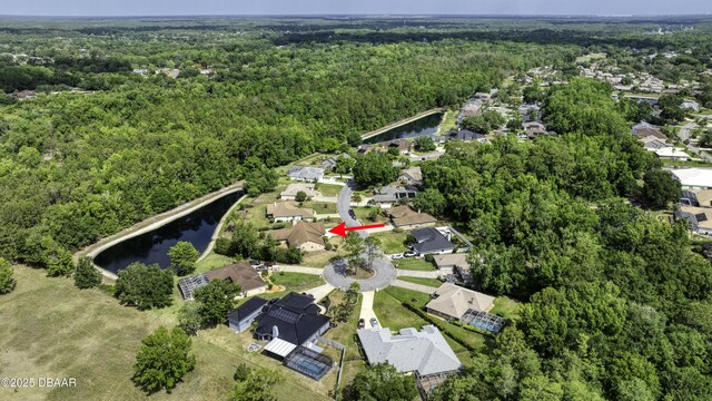 drone / aerial view with a water view, a view of trees, and a residential view