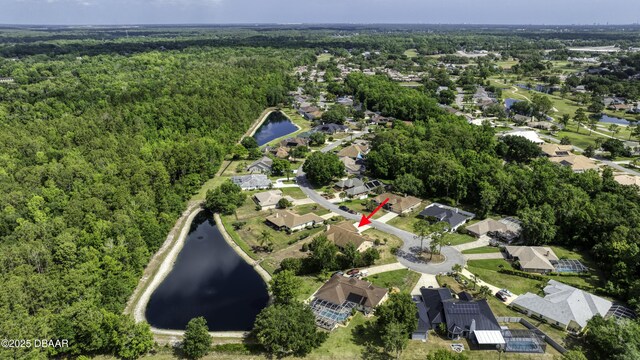 drone / aerial view with a water view, a view of trees, and a residential view