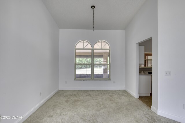 unfurnished dining area featuring baseboards and carpet flooring