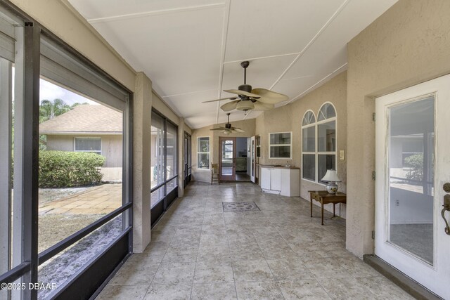 sunroom / solarium with a ceiling fan and vaulted ceiling