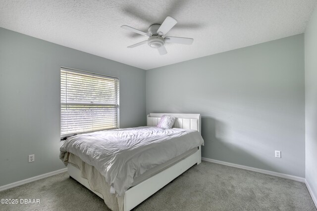 carpeted bedroom with baseboards, a ceiling fan, and a textured ceiling