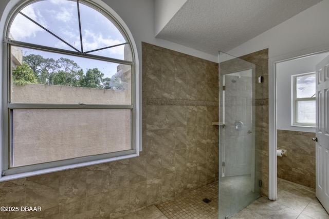 bathroom featuring a walk in shower, tile patterned floors, and a textured ceiling