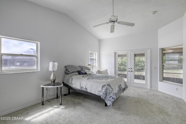 bedroom featuring access to outside, vaulted ceiling, multiple windows, and french doors