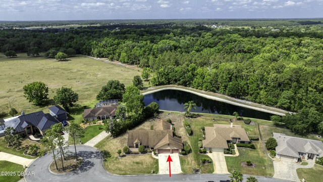 aerial view featuring a forest view and a water view