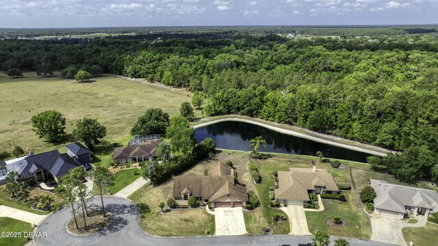 birds eye view of property featuring a water view and a forest view