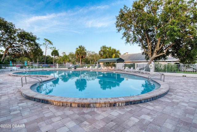 pool with a patio and fence