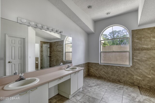 bathroom with a sink, a stall shower, and a wealth of natural light