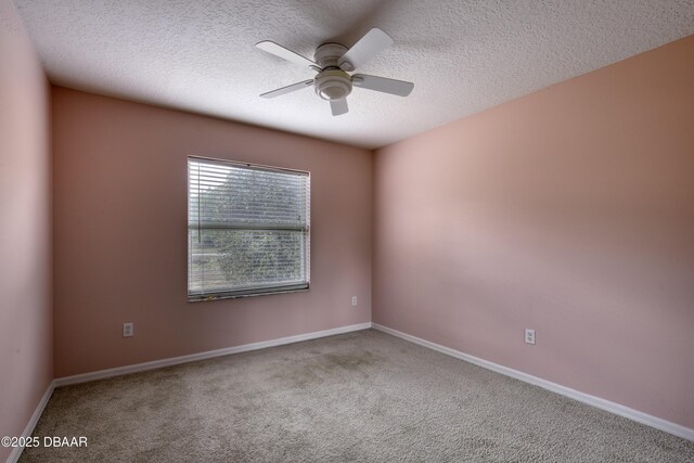 carpeted empty room with baseboards, a textured ceiling, and ceiling fan