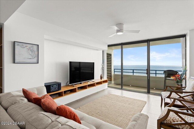 living room featuring expansive windows, light tile patterned flooring, and ceiling fan