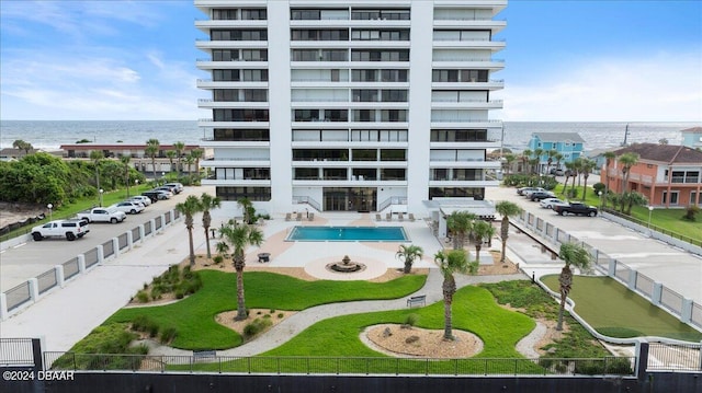 view of building exterior featuring a water view and a community pool