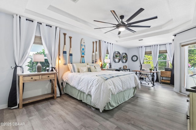 30 Bay Ct, Ormond Beach, FL 32174 - bedroom with a tray ceiling, wood finished floors, access to exterior, and ceiling fan